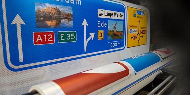 Colorful digitally printed signs on a roll of reflective sheeting.
