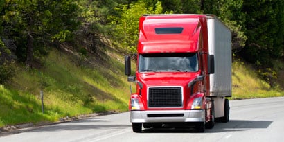 Semi-truck driving down road