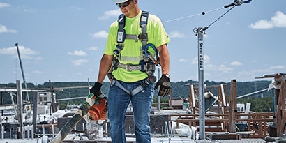 Man clmbing ladder wearing 3M DBI-SALA Permanent Lifeline System
