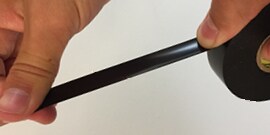 hands stretching tape on roll of Scotch® Vinyl Electrical Tape Super 33+™