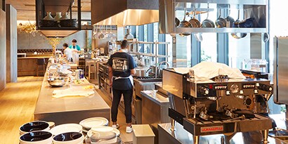 Un restaurante moderno con una cocina comercial funcional y organizada.
