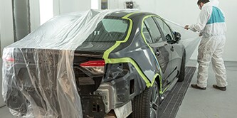 Técnico completando el proceso de enmascarado para pintura de carrocería.
