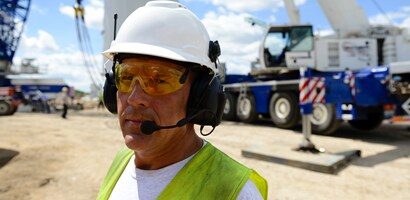 Trabajador con comunicaciones protectoras 3M Peltor en zona de construcción
