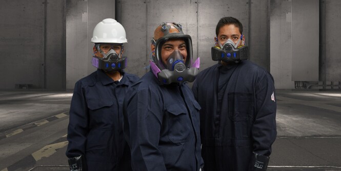 Tres trabajadores de pie con uniformes y respiradores Secure Click
