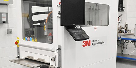 Image of a gantry system with an entry slot and two windows for process visibility
