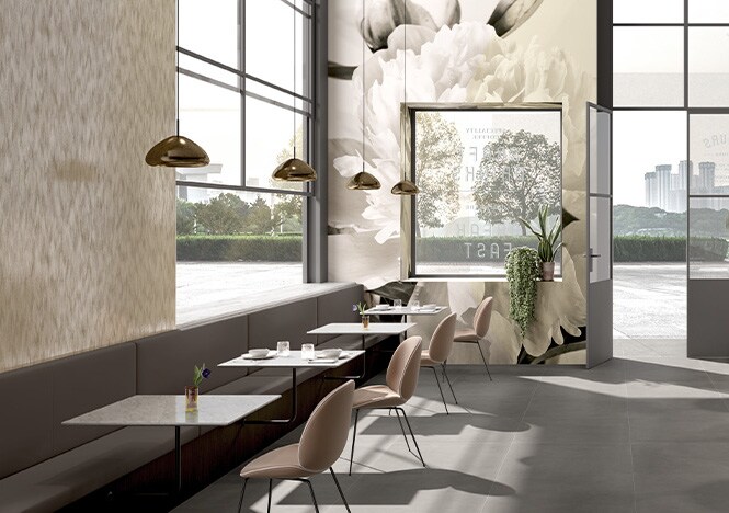 Interior de una cafetería decorado con tonos neutros y un estampado floral impreso sobre film gráfico que recubre las paredes.