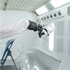Técnico de pintura pulverizando piezas soltas.