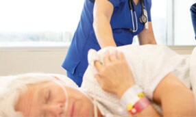 Clinician monitoring a patient with a pressure injury
