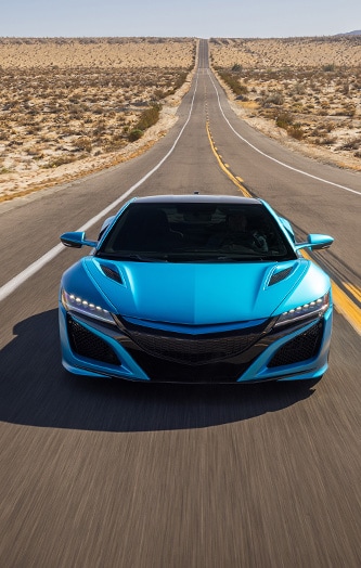 Auto deportivo con vinilo decorativo azul brillante oceánico circulando por la carretera del desierto.
