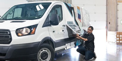 man wrapping a large van with 3M wrap
