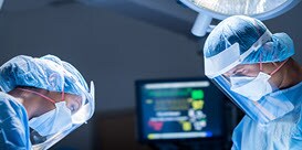 two healthcare professionals working together in a surgery room setting
