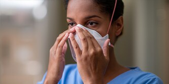 Clinician fitting a filtering facepiece respirator
