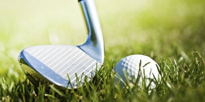 Golf club striking golf ball