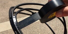Scotch® Vinyl Electrical Tape Super 33+™ being wrapped around a cable outside revealing adhesion