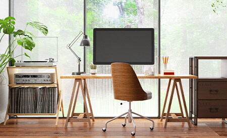 Configuración de escritorio frente a una pared de ventanas revestidas con películas de privacidad de 3M.
