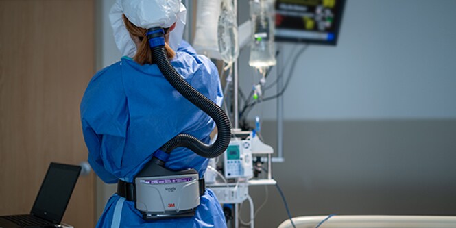 Clinician wearing a powered air-purifying respirator
